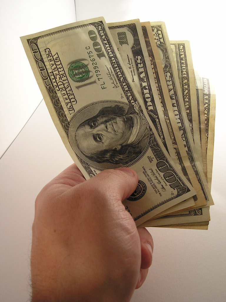 Hand with100 Dollar Bills Over White Background